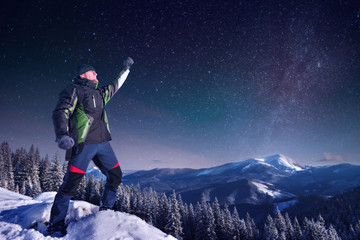 Fototapeta na wymiar Traveler in the mountains in winter hand up Night frame, Milky way star,