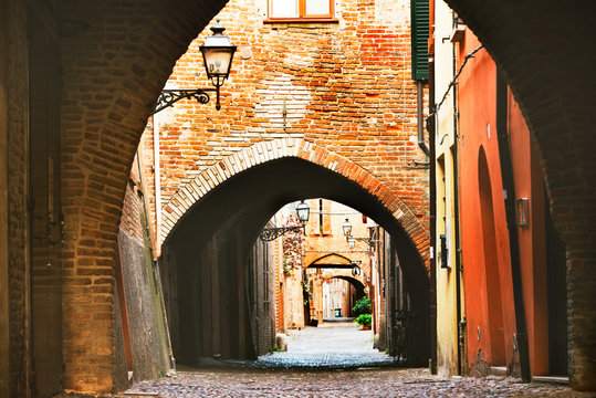 Ferrara, Italy - 22.06.2017: The streets of the historic Italian city of Ferrara, typical Italian narrow streets and with arches, ancient lanterns