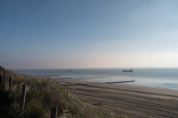 Obraz premium Beach with dunes at daytime. Beautiful dreamy shot of the endless sea in Zoutelande, Netherlands