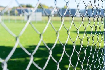 football field seen through iron fence