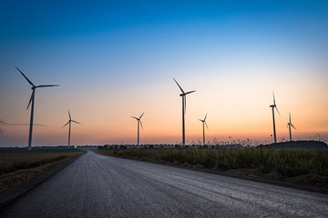 Obraz premium Beautiful silhouette of multiple wind turbines at sunset. Depiction of innovative and sustainable energy and the fight against climate change in Europe. Bedburg, Germany.
