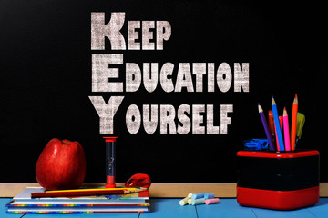 Motivation text keep education yourself on  school black chalkboard with school accessories