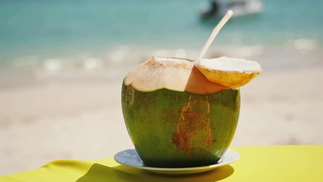 Fresh coconut on the table at the beach cafe. Slow motion. 1920x1080