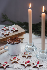 Christmas and New Year cozy holiday composition with candles, mug with cocoa or chocolate, marshmallow, cookies or gingerbread on the wooden white background, vertical