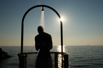 Man showering overlooking the ocean