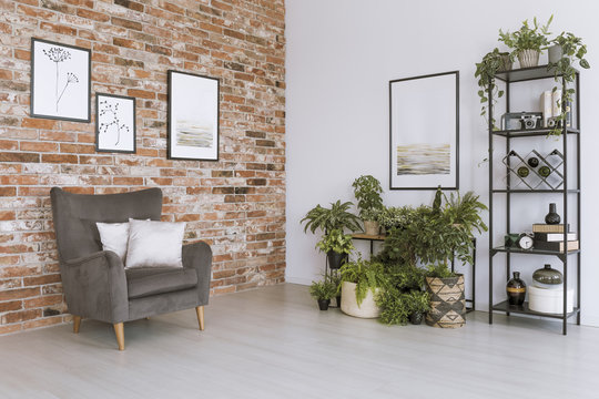 Grey armchair against brick wall
