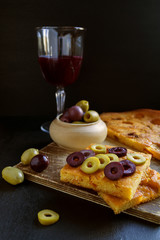 Olives with bread and wine on a black background.