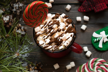 Cocoa with marshmallows and chocolate among fir branches and New Year's elements
