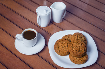 Cup of coffee and cookies on wooden background
