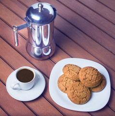 Cup of coffee and cookies on wooden background