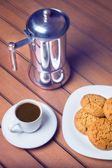 Coffee cup and cookie on wood