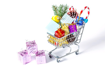 New Year's gifts in a shopping trolley close-up isolated on a white background. A shopping cart full of Christmas gifts isolated on white background.