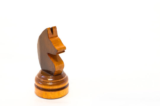 The black chess knight of wood on the white background