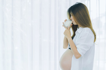 Beautiful pregnant woman is drinking milk, healthy concept