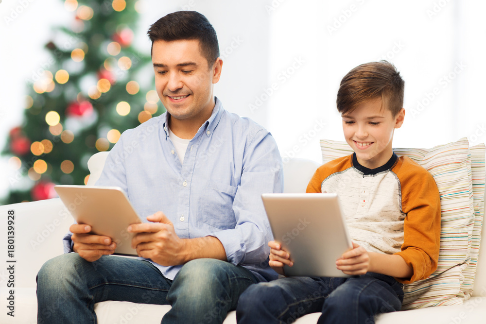 Poster happy father and son with tablet pc at christmas