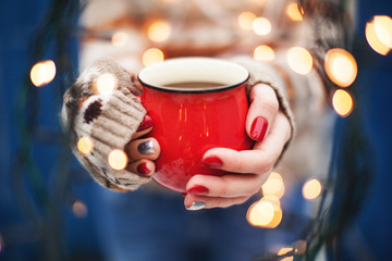 Female hands holding a cup. New Year or Christmas card