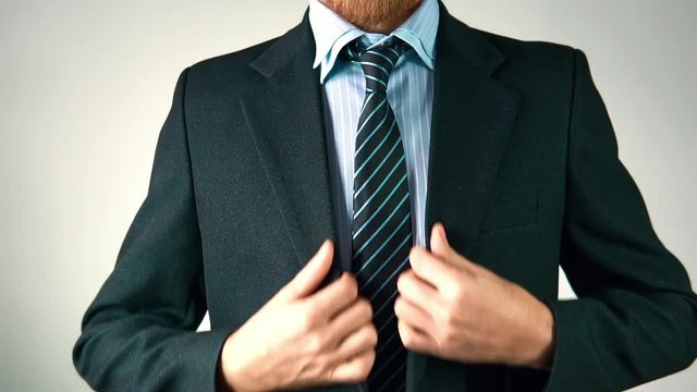 slow motion, a stylish man in a suit with a tie shows a nice and suits his jacket.