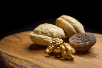 Macaroons, Crushed Walnuts And Dried Apricots On A Wooden Surface