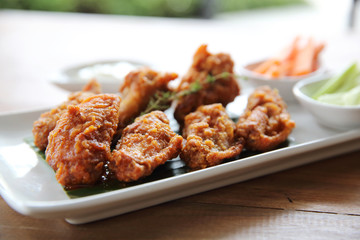 Buffalo wings barbecue chicken with carrots  and cucumbers on wood background