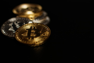 Stack ofgold and silver bitcoins on black background 