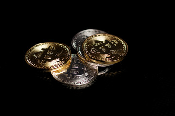Stack ofgold and silver bitcoins on black background 