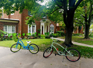 Fototapeta na wymiar Two Bicycles In Driveway of Brick House