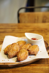 Fried chicken wings on wood background with restaurant light