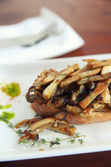 Crispy toasted white bread with mushrooms on wood background table