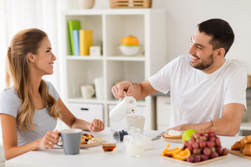 Obraz na płótnie Canvas happy couple having breakfast at home