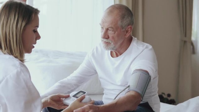 Health visitor and a senior man during home visit.