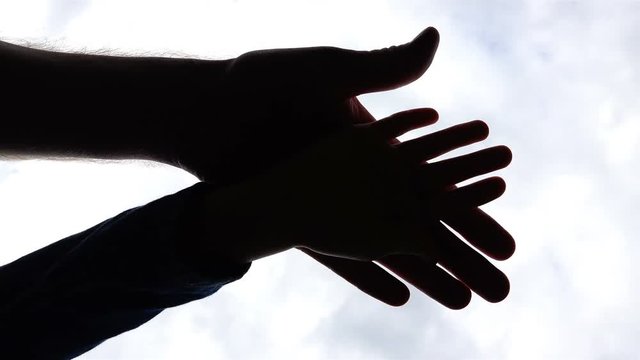 generations of different growths put their palms together as a sign of unity