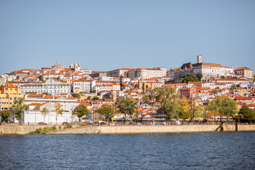 Cityscape view on the old town of Coimbra city with Mondego river during the sunny day in the central Portugal