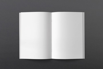 Opened Magazine or Brochure on black paper. Blank pages top view. Mockup template for your showcase.