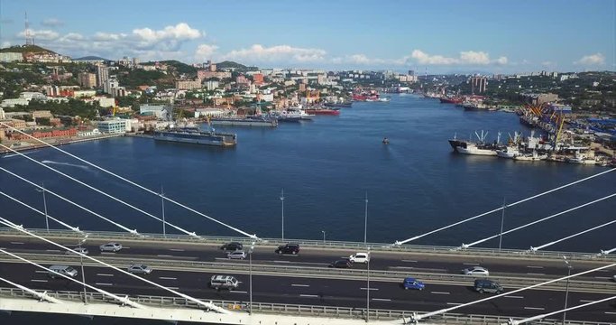 Aerial view of the driving along the cable-stayed Golden Bridge (built in 2012) and the Zolotoy Rog (Golden Horn) harbour with different ships and boats moored here. Vladivostok, Russia