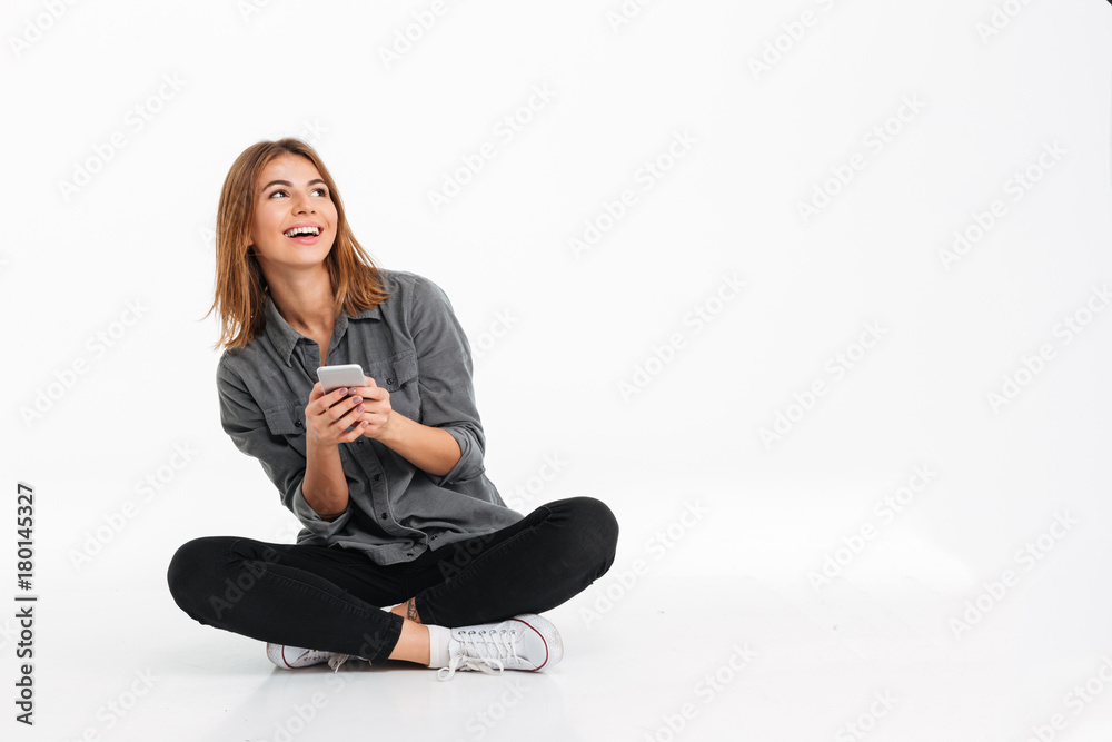 Sticker Portrait of a cheery young girl holding mobile phone