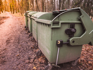 Garbage containers stand in a row.
