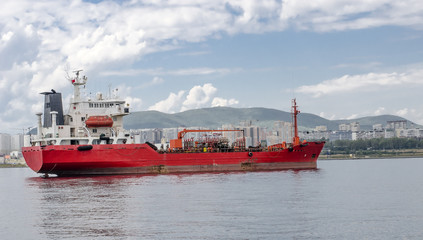Tanker at the shore with highrise buildings.