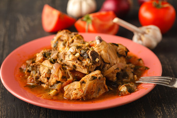 Chakhokhbili - chiken stew with cilantro (parsley) in tomato sauce in a clay bowl,traditional dish of georgian cuisine