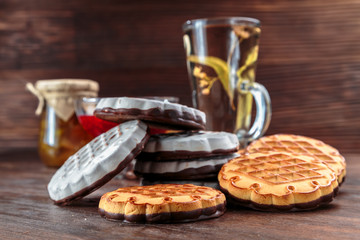 cookies with white chocolate frosting and raspberry jam in a little vase on the table for tea.