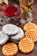 cookies with white chocolate frosting and raspberry jam in a little vase on the table for tea.