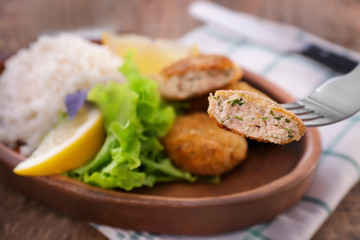 Fork with tasty piece of salmon patty on blurred background