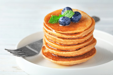 Plate with tasty buckwheat pancakes on table, closeup