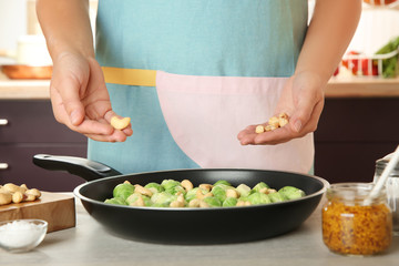 Woman cooking brussels sprouts on table