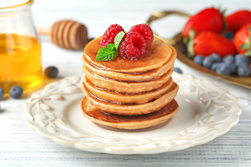 Plate with tasty buckwheat pancakes on table