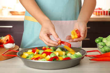 Woman cooking brussels sprouts on table