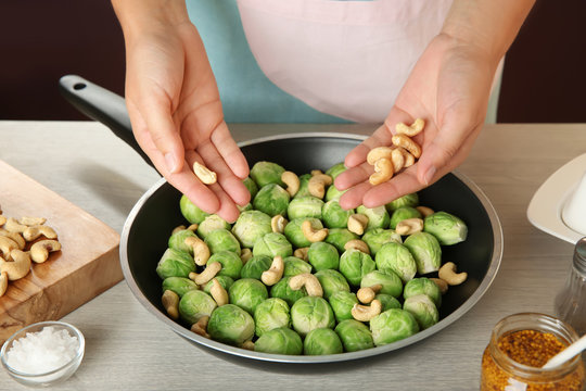 Woman cooking brussels sprouts on table