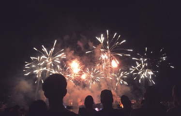 Crowd of Silhouetted People Watching a Fireworks Display for New Years or Fourth of July Celebration, Horizontal - obrazy, fototapety, plakaty