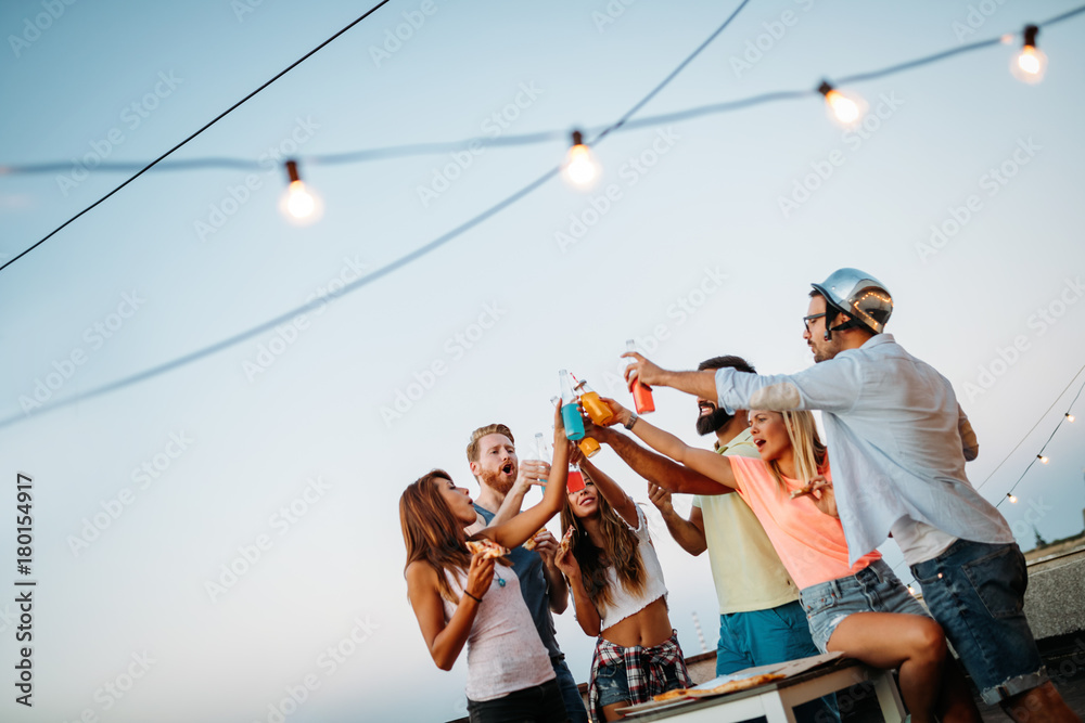 Wall mural Group of happy friends having party on rooftop