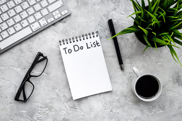 To do list for businessman in notebook on office table. Grey background top view