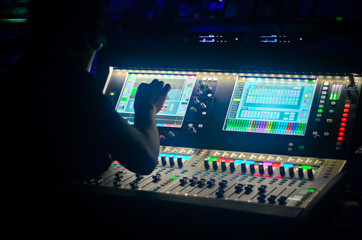 Sound engineer working at mixing panel in the boutique recording in pub